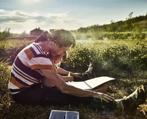 Mann und Kind lesen im Feld