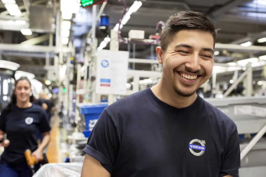 Glücklicher Mitarbeiter von Volvo lacht bei der Arbeit